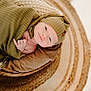 baby, infant, blanket, hat, basket, rug, knitwear, child, portrait, cozy, soft_lighting, smile, cute, newborn, indoor, warm_colors, texture, resting, wrapped, peaceful