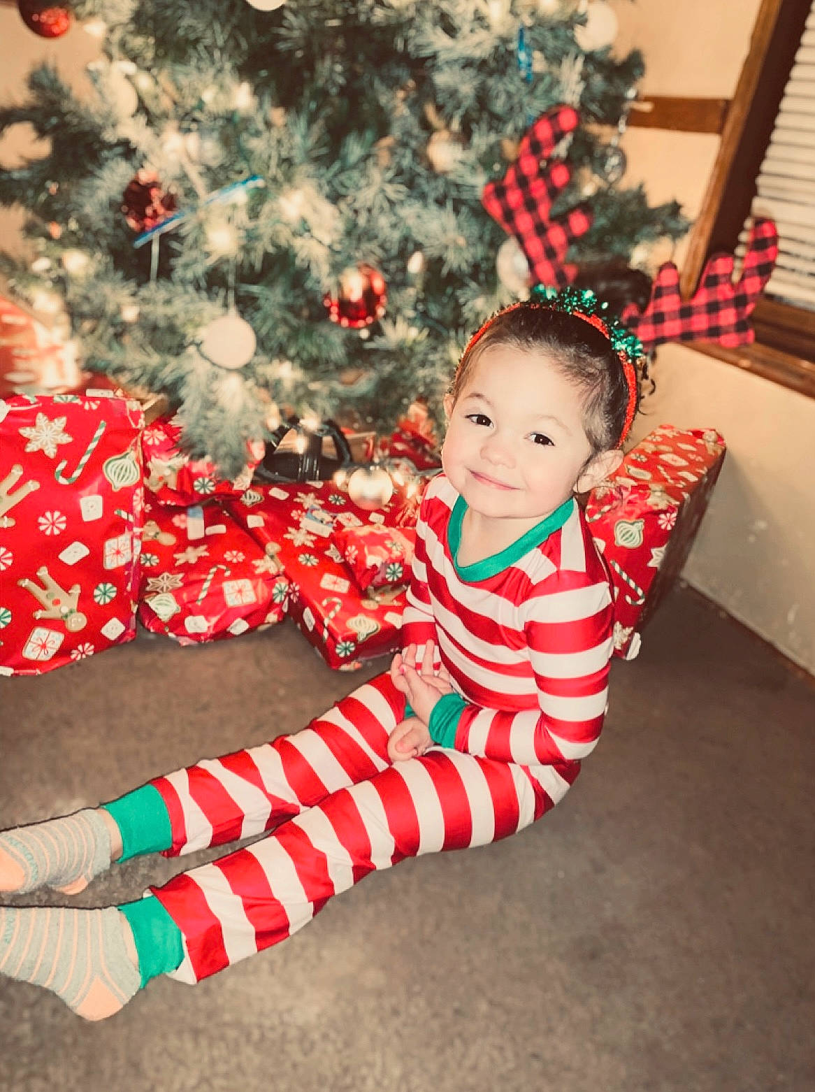 Emmalynn joined the competition — help win amazing prizes! baby, baby_toddler_clothing, child, christmas, christmas_decoration, christmas_ornament, christmas_tree, clothing, dress, face, facial_expression, fun, happy, human_body, joy, person, plant, sleeve, smile, standing