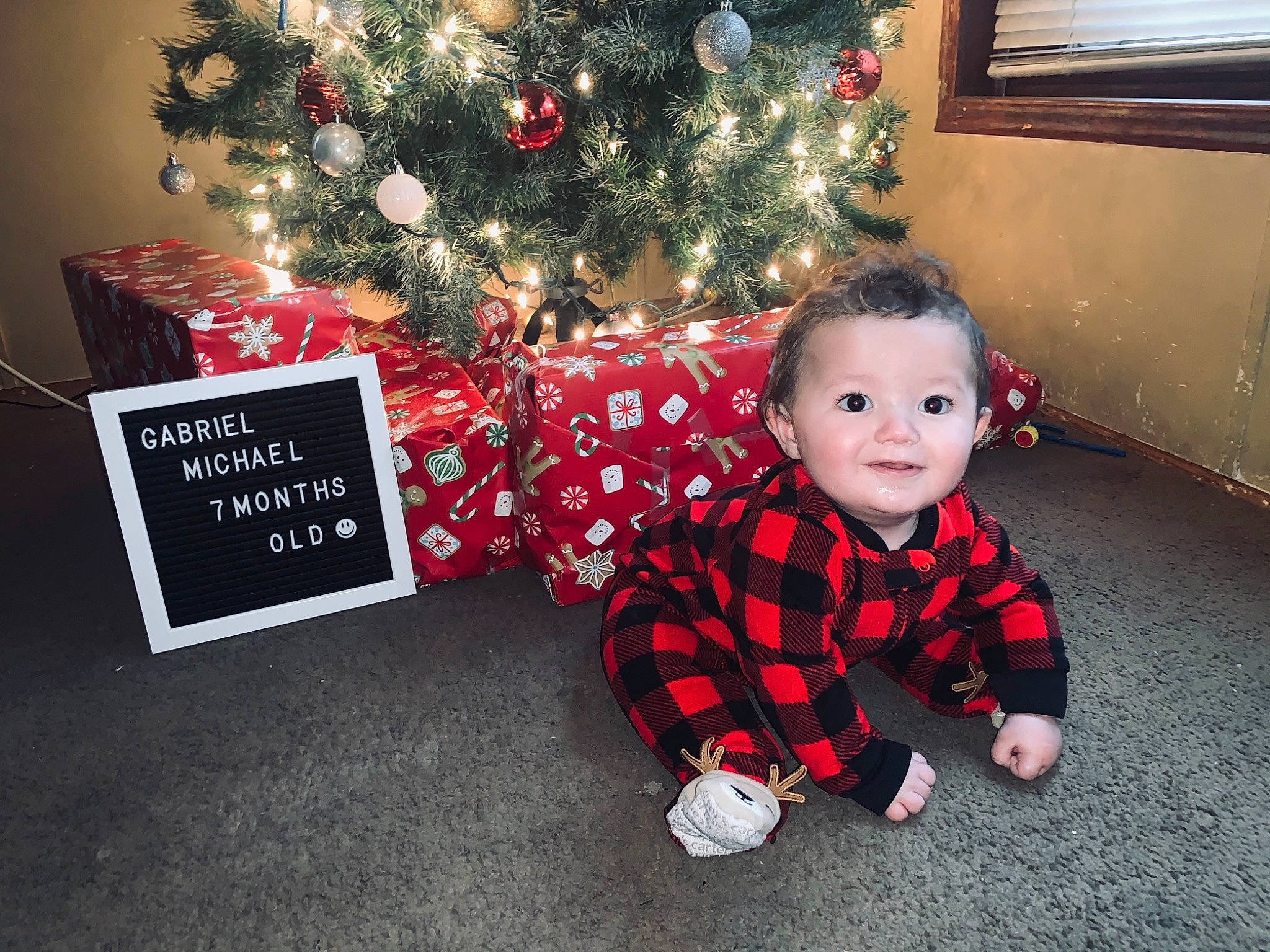 Gabriel joined the competition — help win amazing prizes! baby_toddler_clothing, child, christmas, christmas_decoration, christmas_eve, christmas_ornament, christmas_tree, event, flooring, happy, holiday, holiday_ornament, joy, living_room, ornament, person, plant, red, smile, toddler