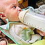 Léandre participe au concours pour gagner de l'argent avec cette photo : baby, infant, bottle, milk, feeding, bib, blanket, hand, face, clothing, dinosaur, crown, table, keyboard, remote, indoor, closeup, cute, child, soft