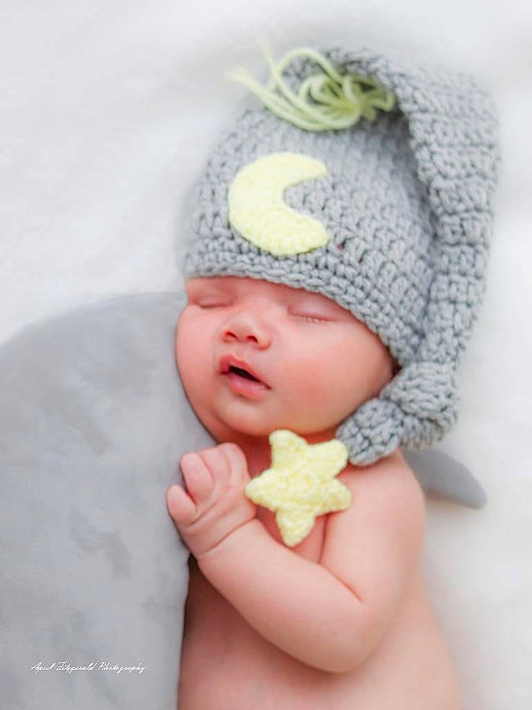 Remington is registered to the contest to win money with this photo: baby, baby_sleeping, baby_toddler_clothing, cap, comfort, eye, finger, gesture, hand, hat, headgear, headwear, human_body, knit_cap, nail, outerwear, pattern, person, thumb, toddler