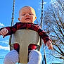 baby, child, swing, playground, outdoor, blue_sky, tree, plaid_shirt, infant, seat, metal_chain, fall, sunlight, fence, person, happy, clothing, legs, nature, daytime