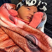 Blakeleigh is registered to the contest to win money with this photo: baby, infant, blanket, headband, pink_clothing, face, wrapped, cozy, newborn, soft_texture, portrait, cute, resting, indoors, child, person, warm, sleepy, closeup, fashion_accessory