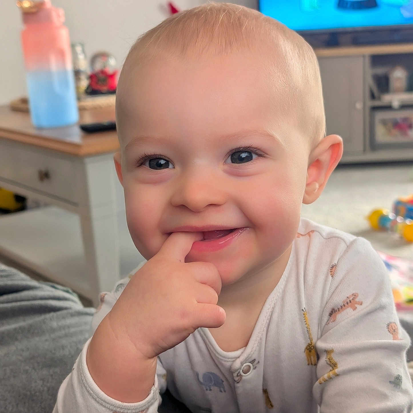 Jaxson joined the competition — help win amazing prizes! baby, blanket, blond_hair, child, cozy, cute, face, finger_in_mouth, furniture, hand, happy, indoor, infant, living_room, pajamas, person, portrait, smiling, television, toy