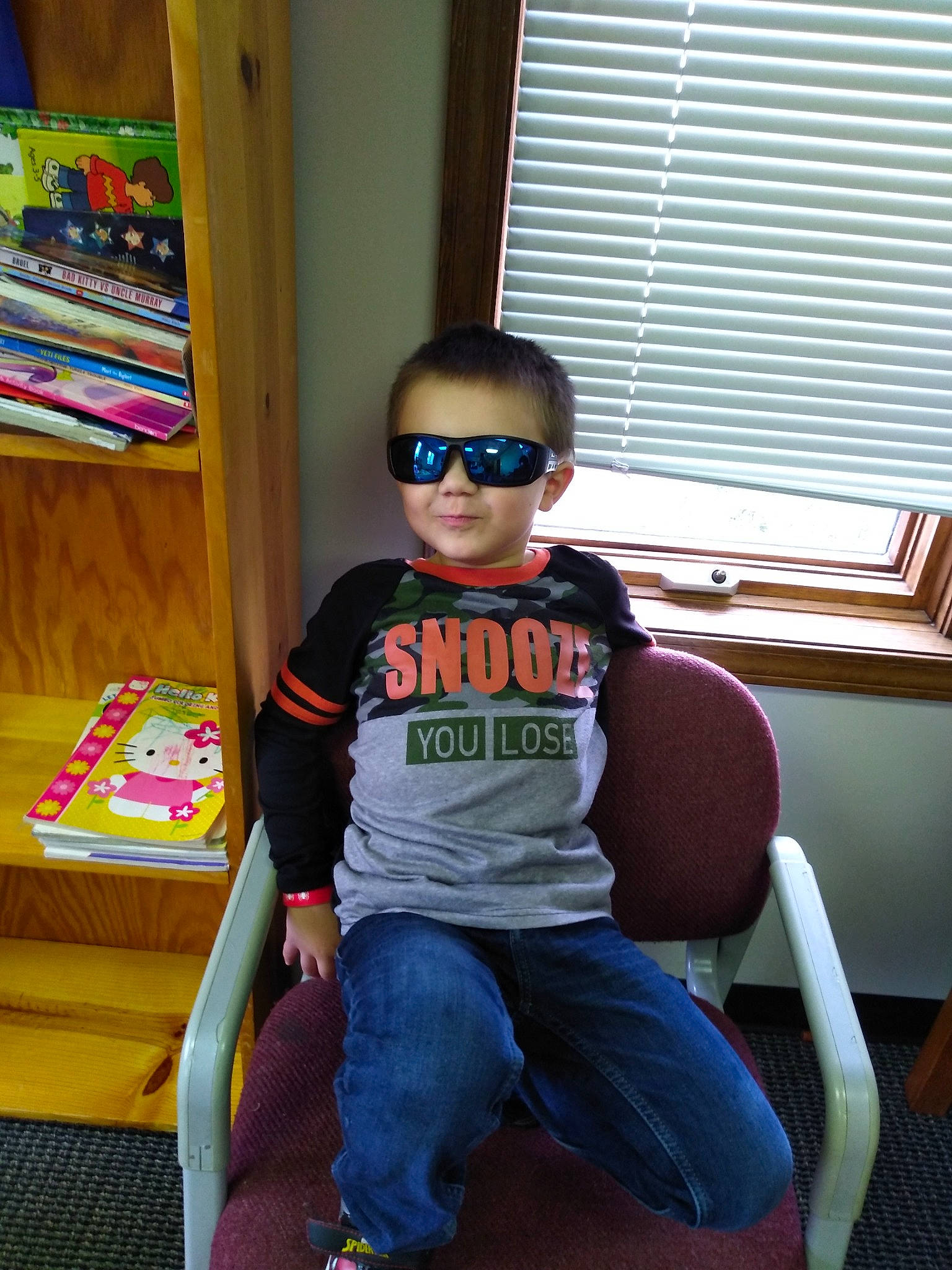 Chad is registered to the contest to win money with this photo: baby_toddler_clothing, child, eyewear, fun, glasses, goggles, jeans, leisure, person, shelf, shorts, sleeve, smile, standing, sunglasses, t_shirt, toddler, vision_care, window, window_blind