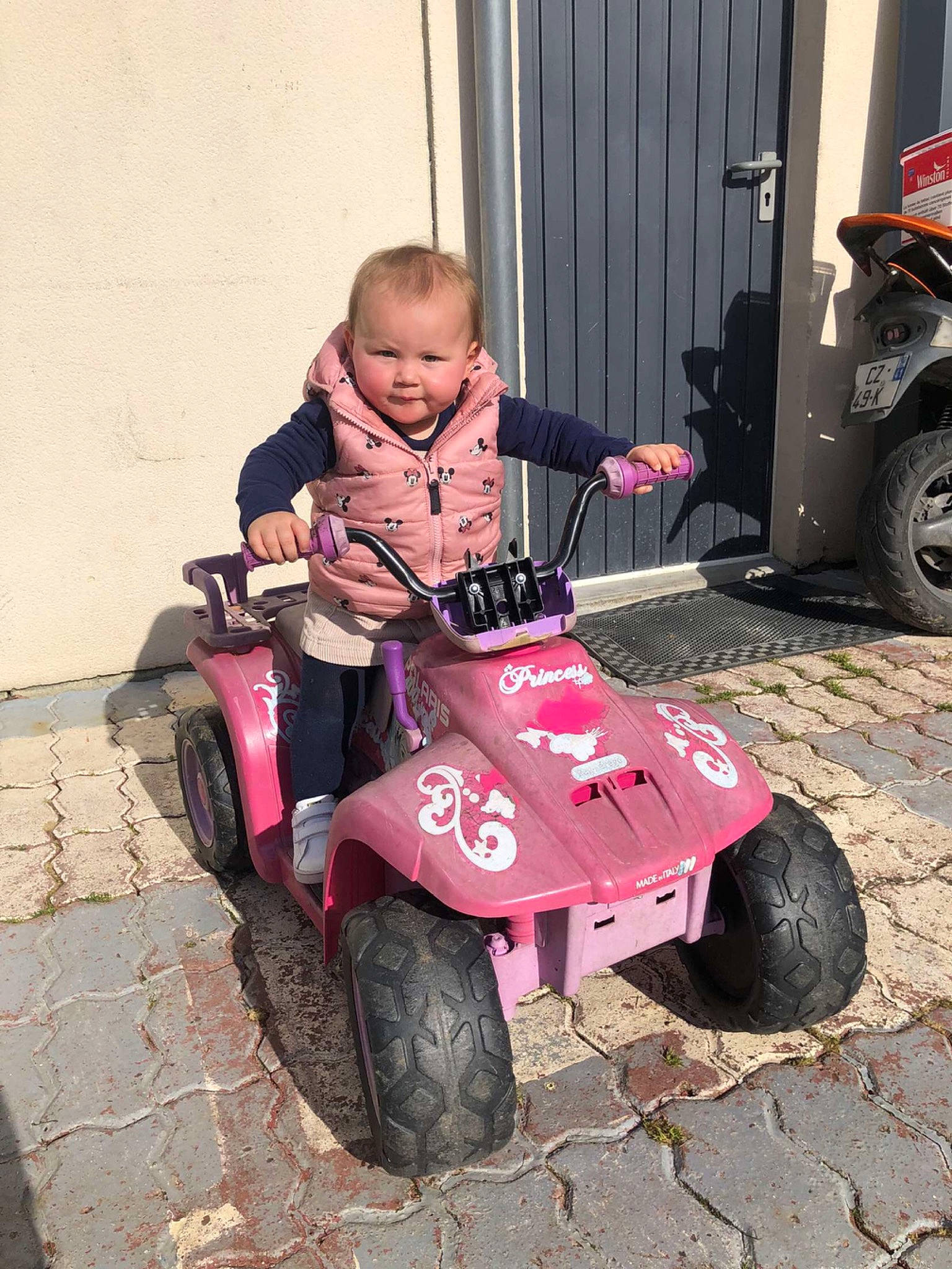 Kataleya participe au concours pour gagner de l'argent avec cette photo : auto_part, automotive_design, automotive_exterior, automotive_tire, automotive_wheel_system, baby, baby_toddler_clothing, fender, fun, motor_vehicle, person, pink, riding_toy, rolling, smile, tire, toddler, toy, tread, vehicle