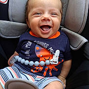 Beau joined the competition — help win amazing prizes! baby, smiling, car_seat, infant, clothing, striped_shorts, orange_octopus, navy_shirt, happy, cute, child, seatbelt, baby_toy, blue_beads, infant_clothing, small_child, car_interior, sitting, playful, joyful