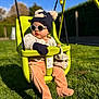 baby, swing, hat, glasses, outdoor, grass, child, sunny, gloves, knitwear, playground, seat, green, blue_sky, pants, cute, toddler, sunshine, relaxing, park