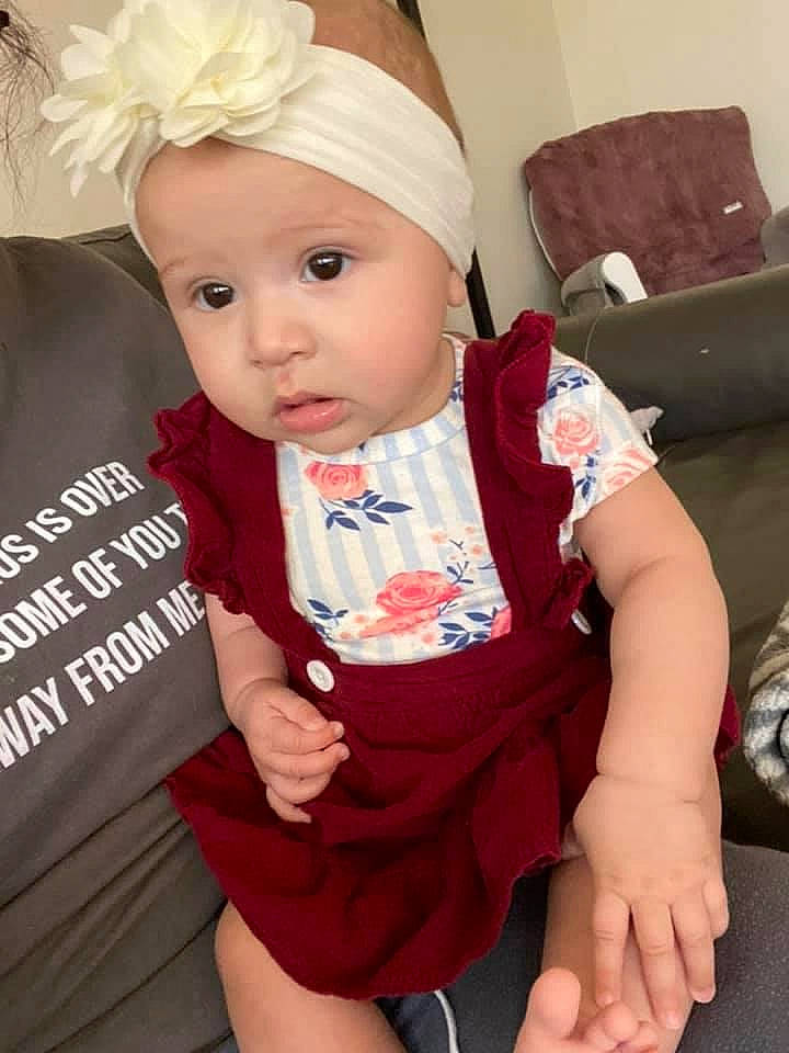 Gracelynn is registered to the contest to win money with this photo: arm, baby, baby_toddler_clothing, cap, cheek, comfort, costume_hat, dress, finger, hand, happy, hat, headband, headgear, headpiece, headwear, lip, person, pink, skin