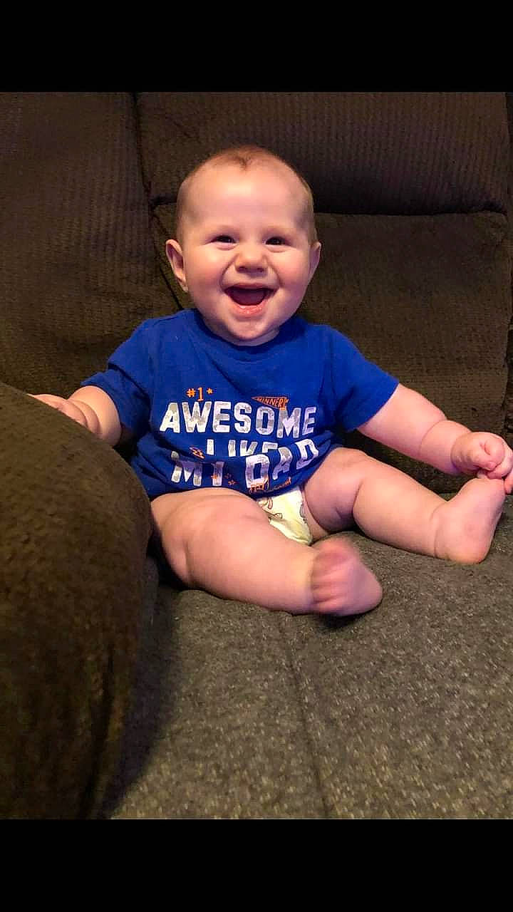 Chandler is registered to the contest to win money with this photo: baby, baby_toddler_clothing, cheek, comfort, couch, eye, finger, flash_photography, floor, fun, happy, head, joy, mammal, mouth, person, skin, sleeve, smile, standing