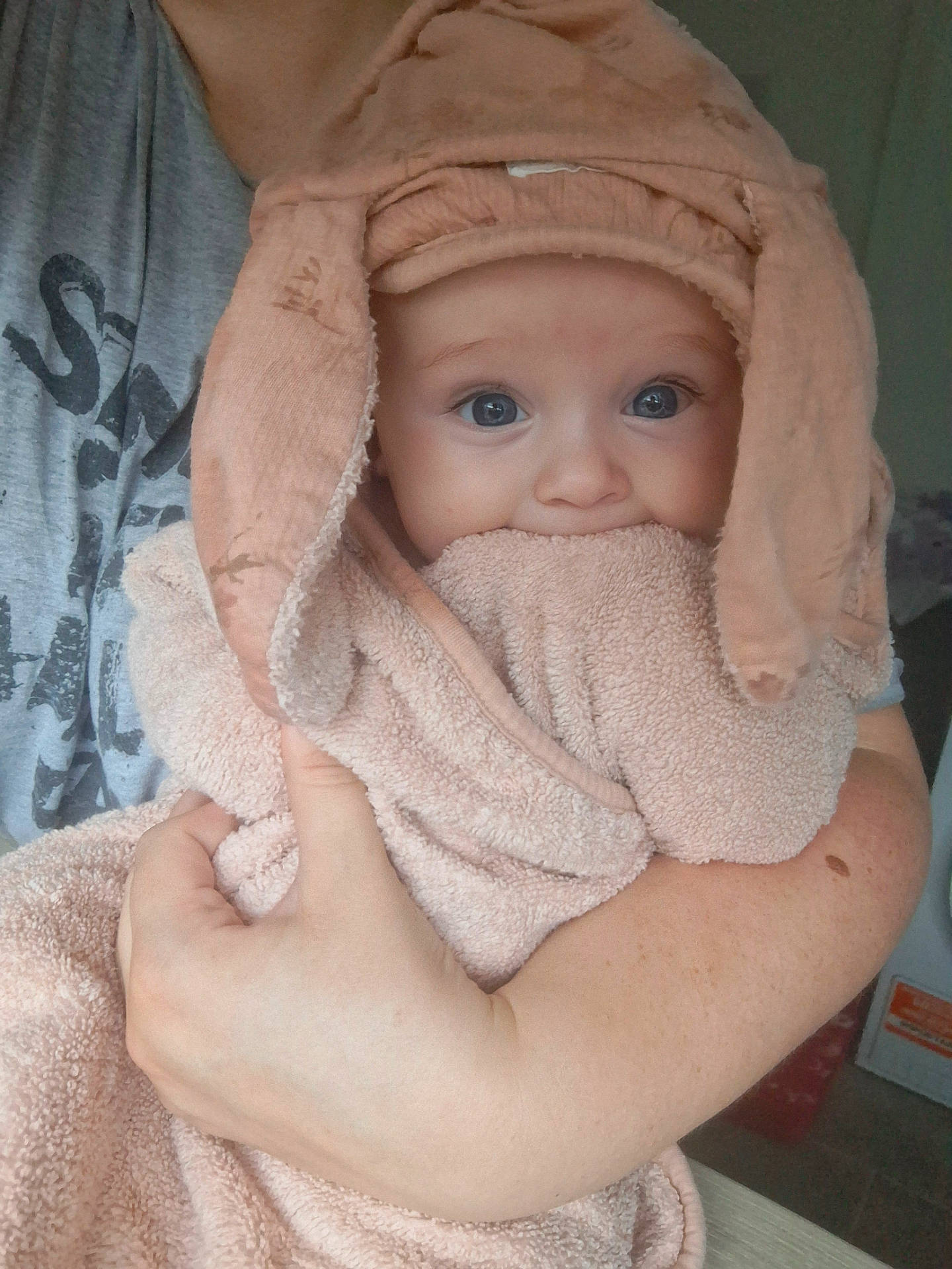 Florence-Louise is registered to the contest to win money with this photo: adult, arm, baby, child, clothing, curious, cute, ears, hand, holding, hood, indoor, peach, person, portrait, skin, soft, towel, wide_eyes, wrapped