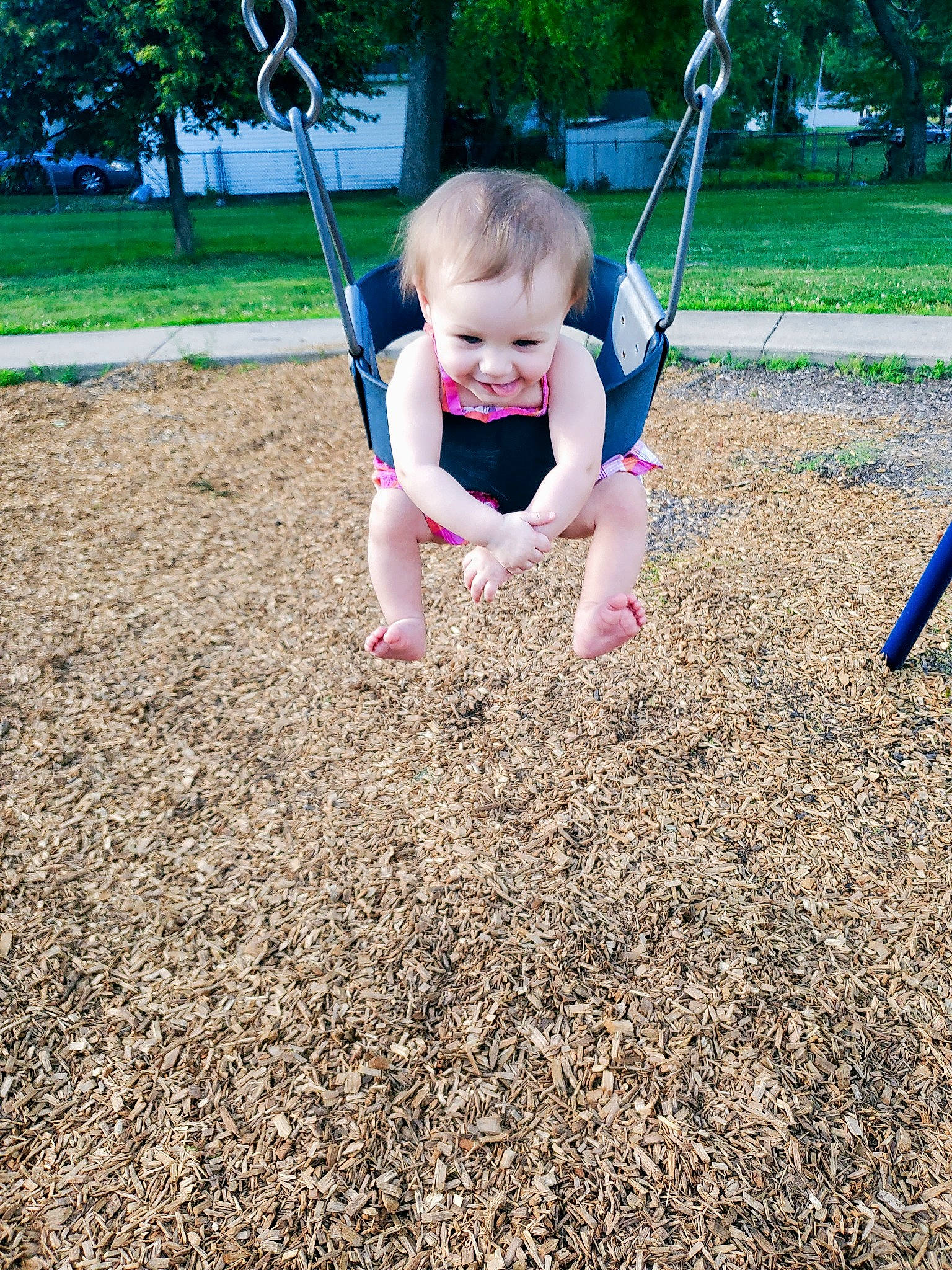 Kora is registered to the contest to win money with this photo: baby, child, city, fun, grass, happy, joy, leisure, outdoor_play_equipment, people_in_nature, person, plant, play, playground, playing_sports, recreation, shorts, soil, swing, t_shirt