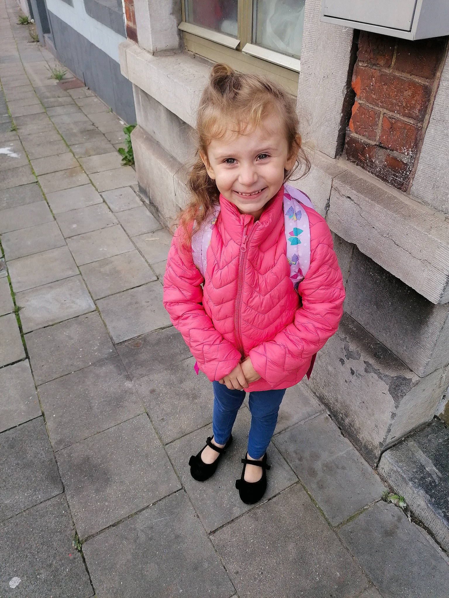 Salomé participe au concours pour gagner de l'argent avec cette photo : asphalt, baby_toddler_clothing, child, concrete, flooring, grass, happy, human_settlement, jacket, joy, line, magenta, people, person, pink, road_surface, sidewalk, sitting, smile, toddler