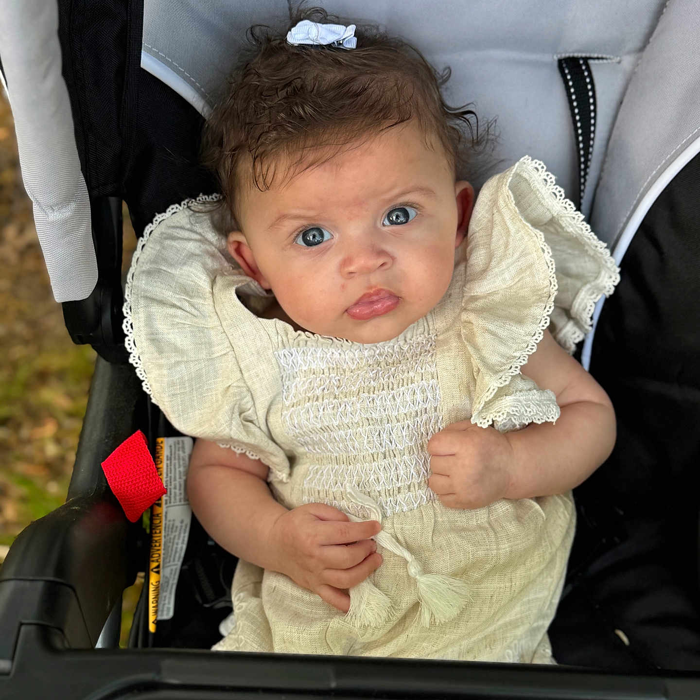 Leila is registered to the contest to win money with this photo: baby, bodypart, bonnet, car, car_interior, clothing, dress, face, finger, hand, hat, head, knitwear, newborn, pants, person, photography, portrait, stroller, sweater