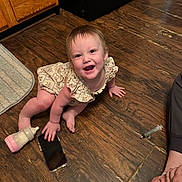Paisley joined the competition — help win amazing prizes! baby, bottle, cabinet, child, crawling, cute, flooring, floral_dress, foot, hand, happy, home, indoor, infant, person, rug, smartphone, smiling, syringe, wooden_floor