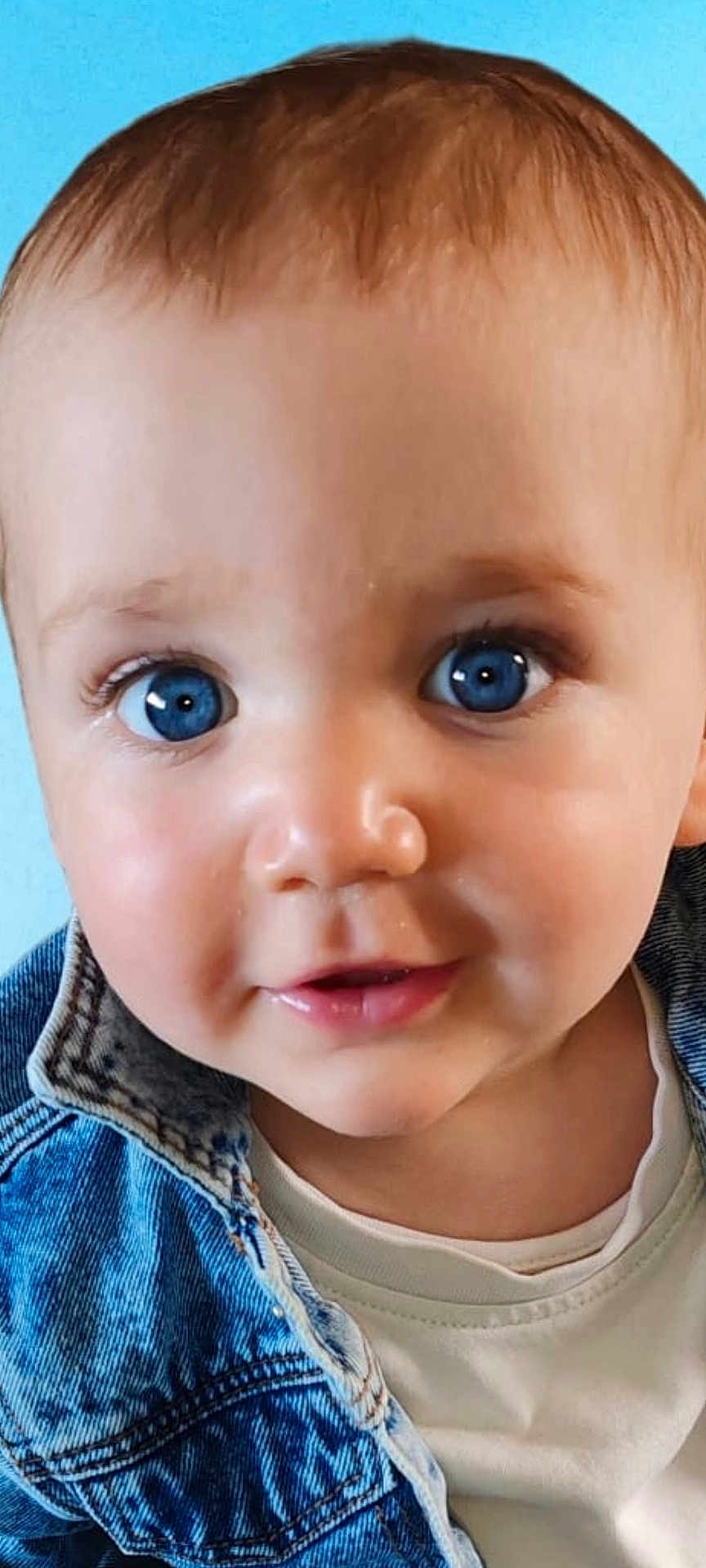 Theodore is registered to the contest to win money with this photo: baby, face, blue_eyes, denim_jacket, white_shirt, cute, child, portrait, skin, smile, young, infant, closeup, person, head, innocence, expression, eyelashes, hair, background