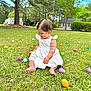 toddler, child, grass, easter_eggs, white_dress, smiling, outdoor, nature, trees, suburban, house, greenery, cute, happy, barefoot, spring, daytime, playful, colorful, baby