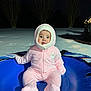 Ayla is registered to the contest to win money with this photo: baby, child, pink_snowsuit, snow_tube, snow, winter, night, outdoor, cold, cute, infant, face, person, sitting, clothing, hood, rosy_cheeks, eyes, snowy_ground, trees
