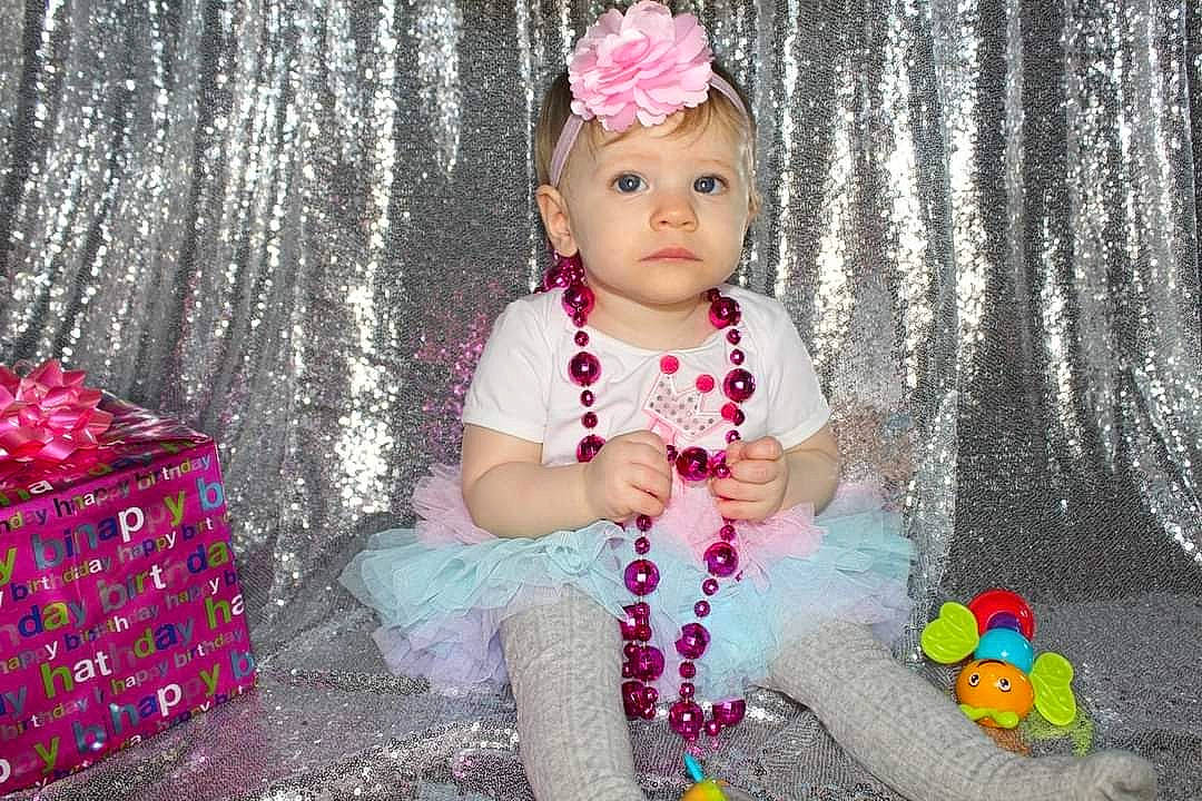 Amelia joined the competition — help win amazing prizes! baby, baby_toddler_clothing, child, dress, eye, fashion_accessory, fun, grass, happy, headpiece, headwear, iris, magenta, pattern, person, pink, purple, sitting, sleeve, standing