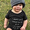 baby, beanie, black_clothing, casual, cheeks, child, cute, expression, eyes, face, grass, hat, infant, nature, outdoor, photography, portrait, serious, sitting, text_on_clothing