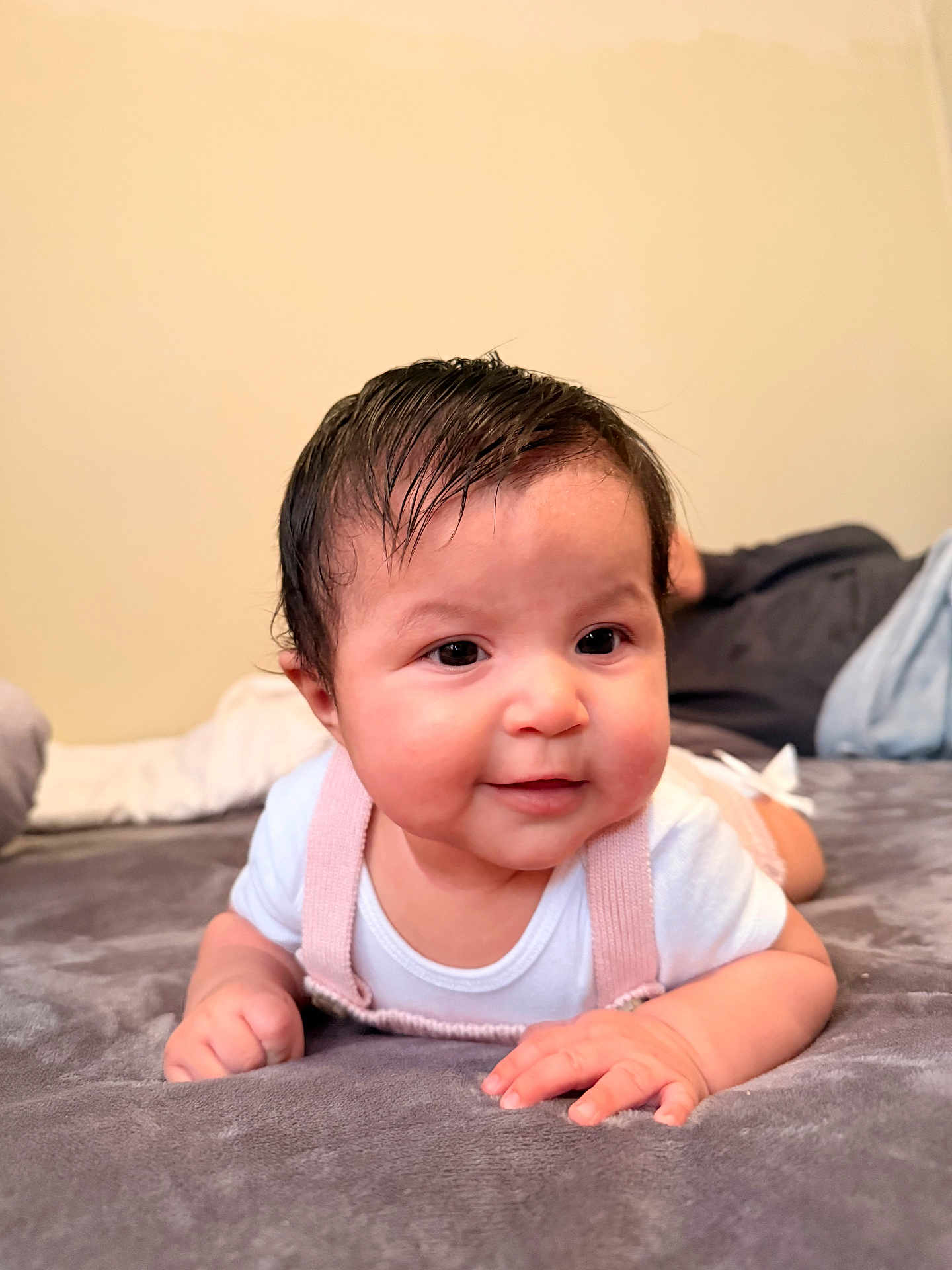 Rossy is registered to the contest to win money with this photo: baby, infant, child, face, smile, hands, lying_down, blanket, indoors, clothing, onesie, pink, white, cute, portrait, skin, hair, expression, young, soft