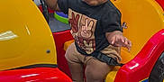 Zyon joined the competition — help win amazing prizes! baby, child, toddler, kiddie_ride, toy_car, indoor, play_area, colorful, red, yellow, cartoon_mouse, seat_belt, footwear, shorts, tshirt, expression, steering_wheel, chairs, tables, carpet