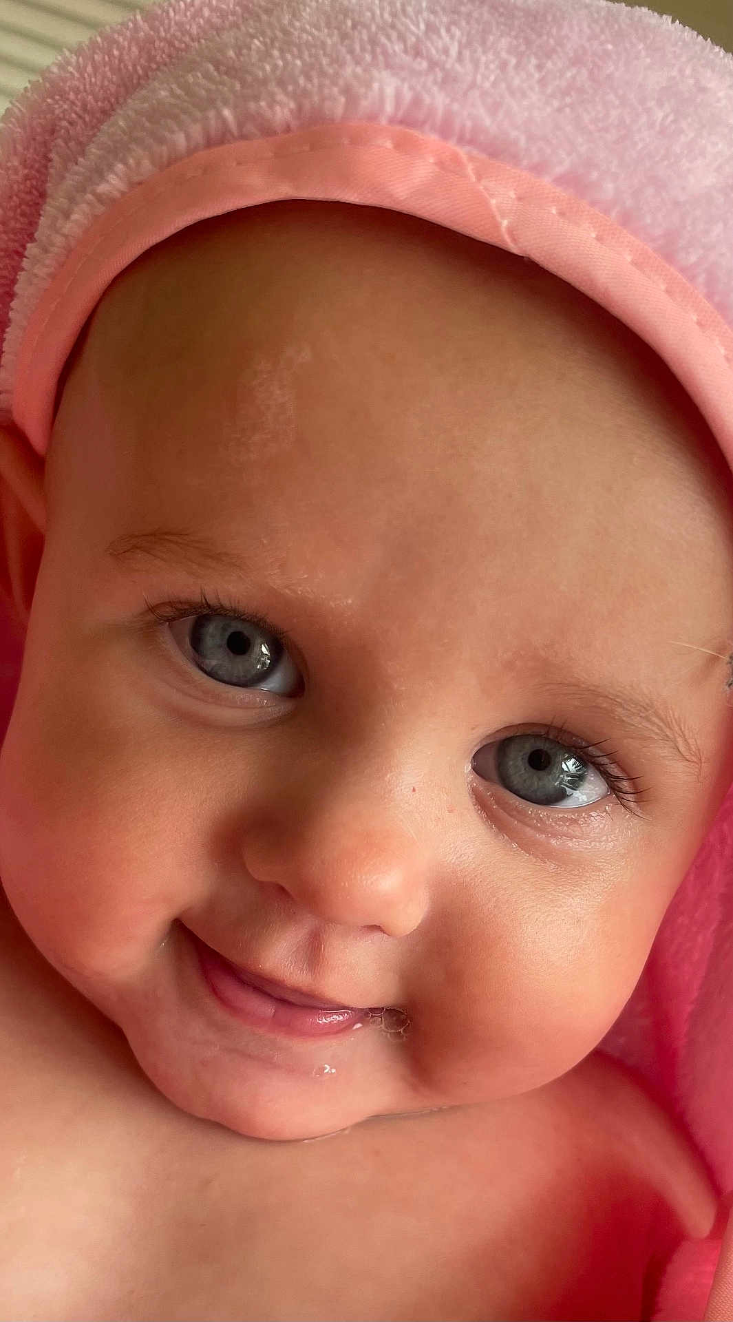 Mabel joined the competition — help win amazing prizes! baby, close_up, face, smiling, blue_eyes, drool, pink_towel, skin, infant, cute, child, portrait, soft_texture, happy, cheeks, head, eyelashes, innocence, warmth, toddler