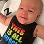 Kohlson joined the competition — help win amazing prizes! baby, smiling, infant, face, clothing, earrings, blanket, text, colorful_text, sleeveless_shirt, lying_down, happy, cute, child, young, skin, person, number_two, indoor, closeup