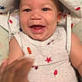 baby, smiling, hat, white_clothing, stars, hot_dog_print, sleeveless_top, infant, happy, hand, cute, indoor, child, face, portrait, expressive, playful, clothing, closeup, cheerful