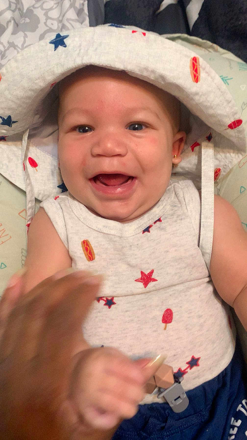 Kohlson joined the competition — help win amazing prizes! baby, smiling, hat, white_clothing, stars, hot_dog_print, sleeveless_top, infant, happy, hand, cute, indoor, child, face, portrait, expressive, playful, clothing, closeup, cheerful