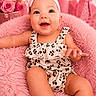 Maddie joined the competition — help win amazing prizes! baby, infant, child, pink, headband, flower, romper, leopard_print, smiling, happy, fluffy_chair, soft_texture, decor, roses, lights, portrait, cute, sitting, indoors, person