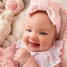 baby, smiling, pink_bow, headband, blanket, plush_toy, flower, knitted, cute, infant, happy, portrait, soft, cozy, child, indoors, closeup, face, fingers, clothing