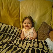 Jana participe au concours pour gagner de l'argent avec cette photo : baby, child, couch, blanket, pattern, smile, indoor, home, face, infant, seated, yellow, cozy, comfort, portrait, furniture, person, young, cute, relaxed