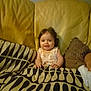baby, child, couch, blanket, pattern, smile, indoor, home, face, infant, seated, yellow, cozy, comfort, portrait, furniture, person, young, cute, relaxed