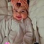 baby, infant, smiling, headband, bow, cute, cozy, blanket, soft, fuzzy, clothing, portrait, child, happy, indoors, face, person, heart_emoji, pink, black