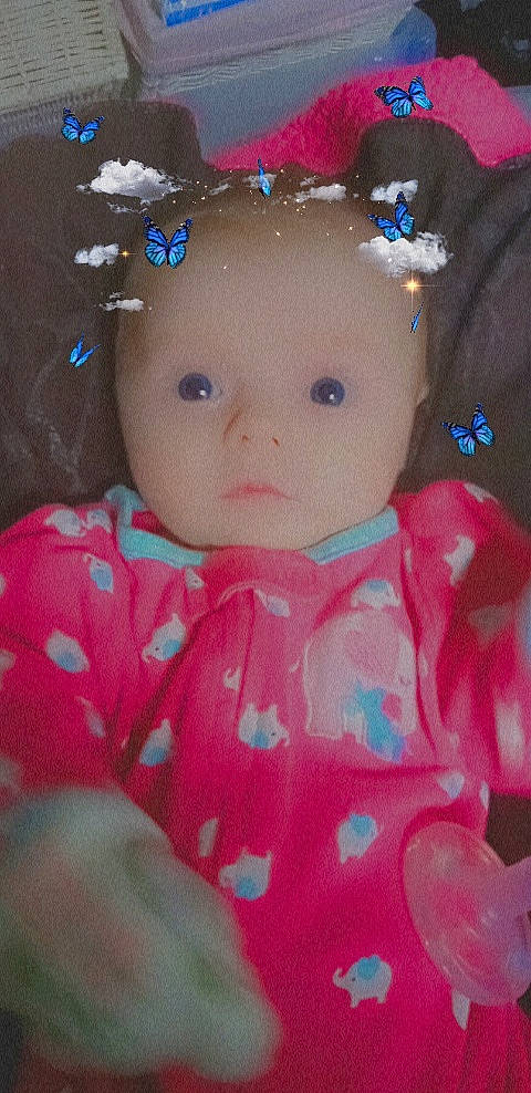 Caroline is registered to the contest to win money with this photo: baby_toddler_clothing, brown_hair, cheek, doll, eyebrow, eyelash, headband, headpiece, iris, jewellery, lip, magenta, nose, pattern, person, pink, skin, sleeve, textile, toddler