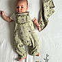 Sam a rejoint le concours — aidez-le/la à gagner de superbes lots ! baby, infant, child, overalls, animal_print, cute, lying_down, white_sheet, tiger_illustration, green_clothing, peaceful, calm, portrait, indoors, small_baby, face, bare_feet, short_hair, soft_light, fabric