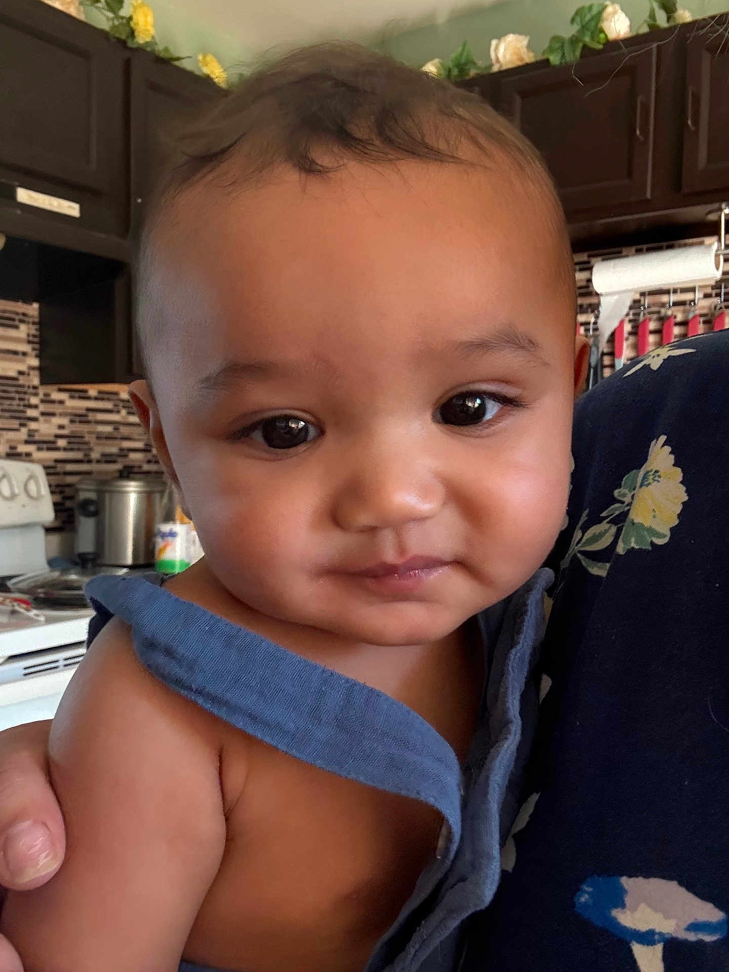 Messiah is registered to the contest to win money with this photo: baby, child, face, portrait, close_up, indoor, kitchen, person, skin, expression, clothing, hand, curly_hair, cute, infant, young_child, holding, warm_lighting, domestic, casual