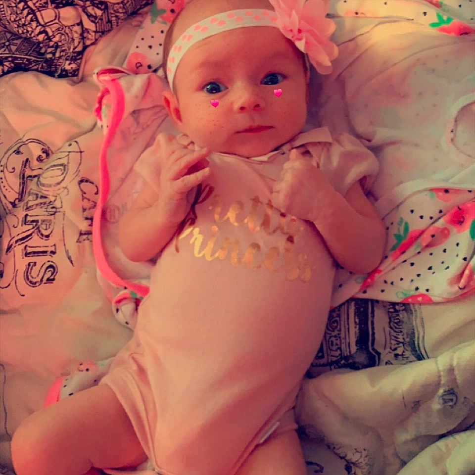 Theresa is registered to the contest to win money with this photo: abdomen, baby, baby_toddler_clothing, cheek, chest, child, comfort, finger, happy, headgear, human_body, human_leg, mouth, pattern, pink, skin, stomach, thigh, toddler, trunk