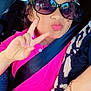 Lina a rejoint le concours — aidez-le/la à gagner de superbes lots ! child, girl, sunglasses, pink_shirt, car_seat, seatbelt, peace_sign, curly_hair, car_interior, window, greenery, playful, casual, portrait, happy, person, sitting, summer, travel, road_trip