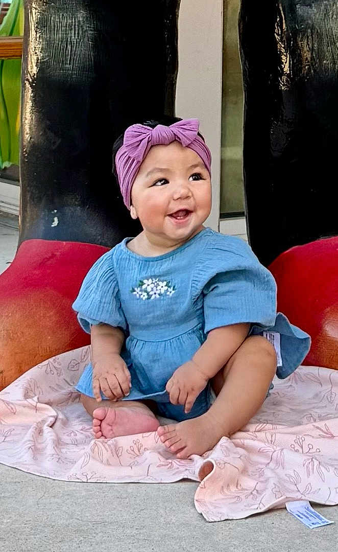 Amelia joined the competition — help win amazing prizes! baby, child, smiling, headband, purple, blue_dress, sitting, blanket, barefoot, happy, outdoor, feet, cute, infant, portrait, person, footwear_background, large_boots, playful, expression