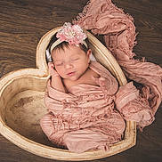 Ivy joined the competition — help win amazing prizes! newborn, baby, sleeping, pink, headband, heart_shaped_bowl, wooden_floor, wrapped, soft_cloth, peaceful, infant, cute, portrait, indoors, resting, close_up, adorable, baby_girl, delicate, cozy