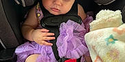 Willow is registered to the contest to win money with this photo: baby, blanket, car_seat, child, clothing, comfort, cute, foot, hands, indoor, infant, nap, peaceful, portrait, purple_dress, safety, seatbelt, sleeping, soft_toy, toddler