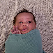 Ryker is registered to the contest to win money with this photo: baby, blanket, cozy, curious, expression, eyes, face, green_wrap, hand, head, indoors, infant, knitted, lying_down, newborn, person, portrait, skin, soft_texture, swaddled