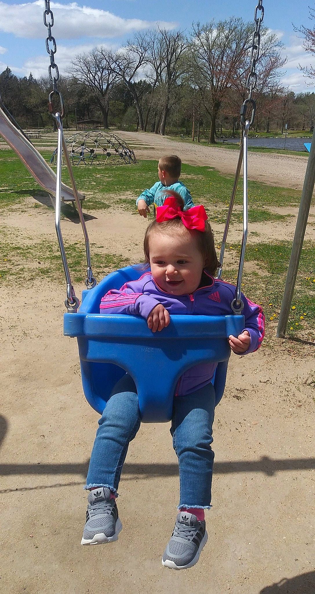 Gabriella joined the competition — help win amazing prizes! baby, baby_toddler_clothing, child, city, electric_blue, fun, grass, happy, leisure, nature, outdoor_play_equipment, people_in_nature, person, plant, playground, public_space, recreation, soil, swing, toddler