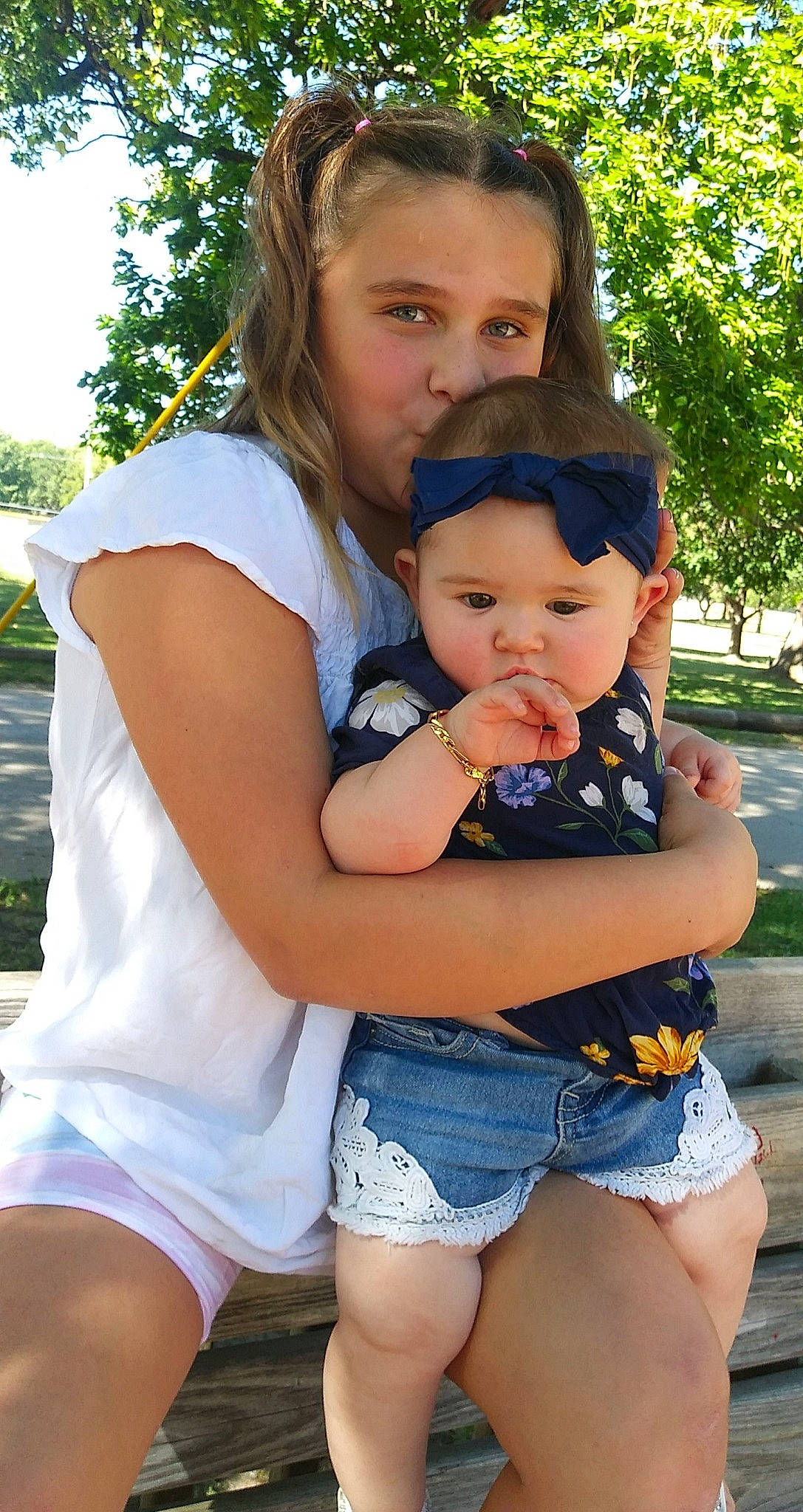 Kiley is registered to the contest to win money with this photo: clothing, cool, eye, face, gesture, grass, hand, happy, headwear, human_body, interaction, jean_short, leg, leisure, people_in_nature, person, plant, shorts, shoulder, thigh