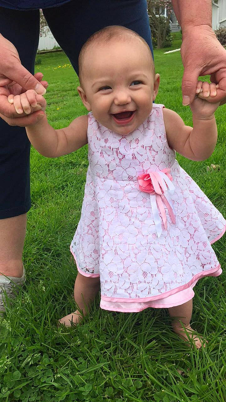 Annalynn is registered to the contest to win money with this photo: baby, cheek, child, dress, facial_expression, finger, fun, gesture, grass, grass_family, hand, happy, joy, lawn, person, pink, plant, play, skin, smile
