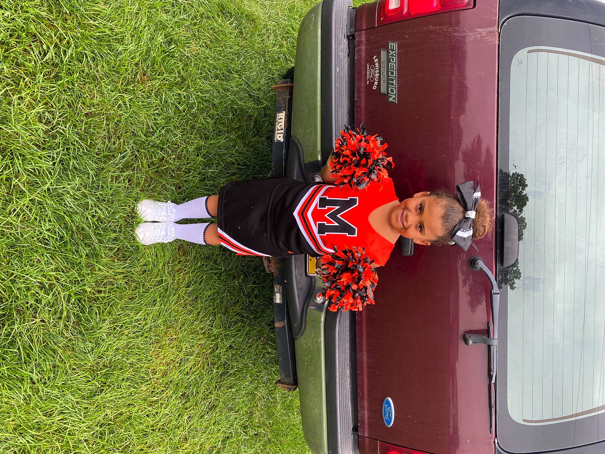 Olivia is registered to the contest to win money with this photo: auto_part, automotive_design, automotive_exterior, automotive_lighting, automotive_tail_brake_light, automotive_wheel_system, automotive_window_part, bumper, car, door, family_car, grass, hood, joy, motor_vehicle, person, plant, red, smile, vehicle