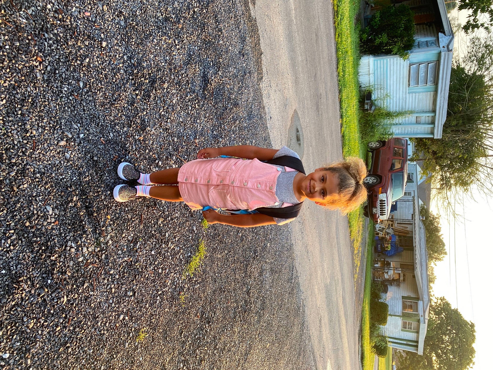 Olivia is registered to the contest to win money with this photo: asphalt, child, fun, grass, human_leg, joy, landscape, leisure, pedestrian, people_in_nature, person, plant, road_surface, shadow, sidewalk, sky, soil, tire, toddler, tree