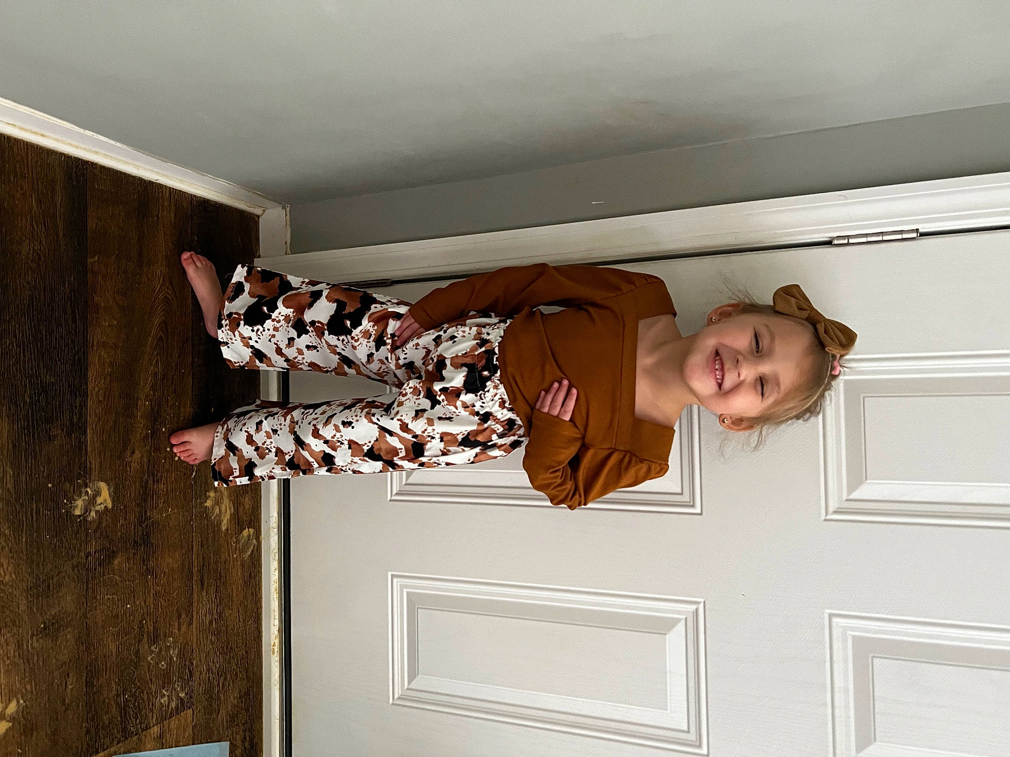 Ava is registered to the contest to win money with this photo: brown, ceiling, door, elbow, fun, gesture, happy, hardwood, home_door, joy, molding, pattern, person, plaster, room, smile, stairs, window_covering, window_treatment, wood